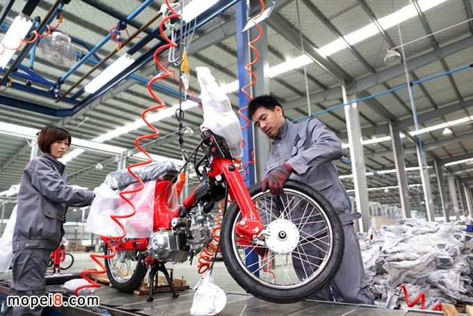 重庆安第斯摩托车技术工人在自动成车流水生产线组装摩托车